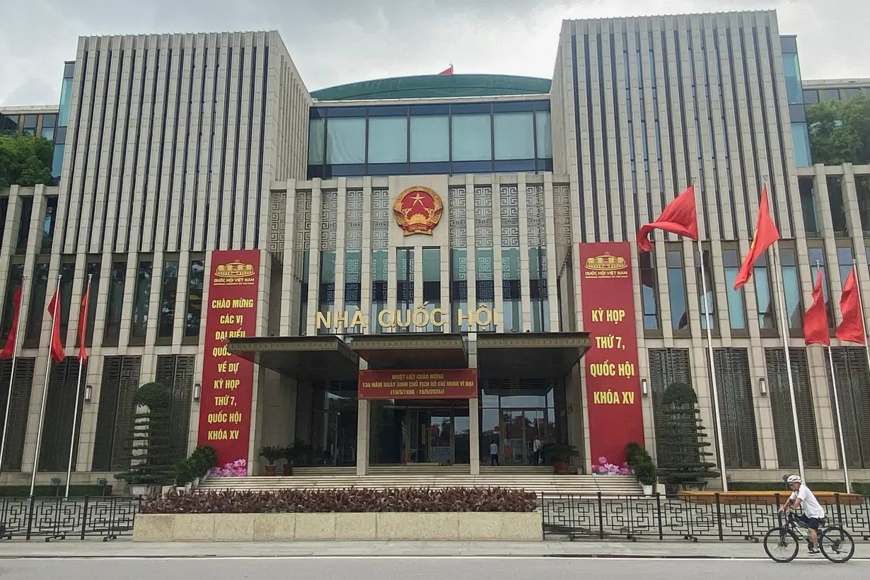 A man cycles in front of the National Assembly Building of Vietnam, in Hanoi