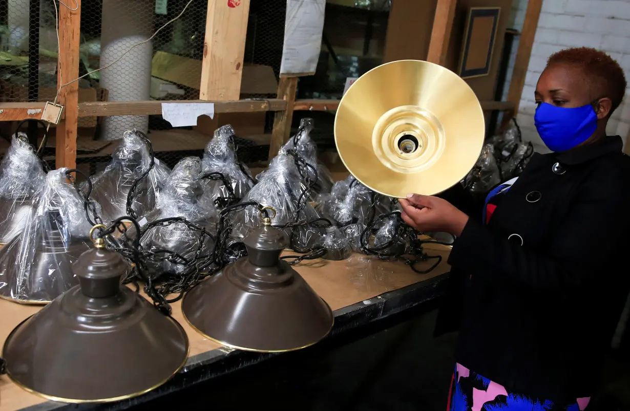 FILE PHOTO: Staff work at copper and silver giftware manufacturer Copperwares workshop in Harare