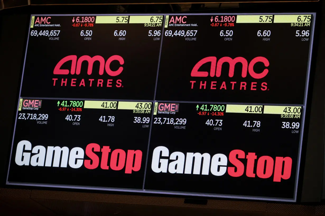 A screen displays the trading information for GameStop and AMC Theatres on the floor of the NYSE in New York