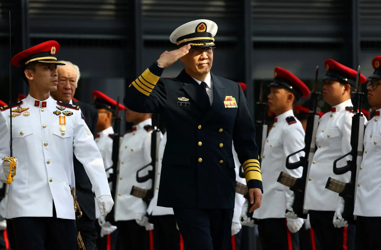 China's newly appointed Defence Minister Dong Jun inspects honour guards in Singapore