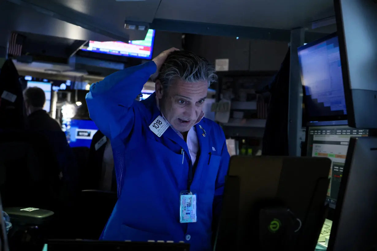 FILE PHOTO: Traders work on the floor of the NYSE in New York