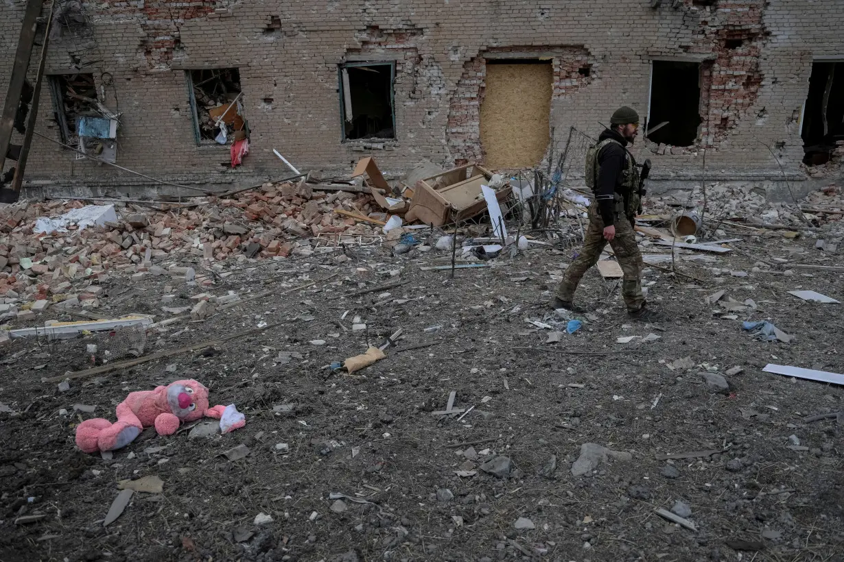 FILE PHOTO: A Ukrainian serviceman walks near destroyed building in the frontline town of Chasiv Yar