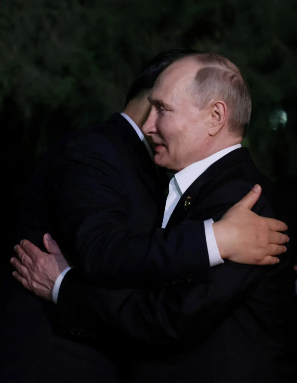 FILE PHOTO: Russian President Vladimir Putin and Chinese President Xi Jinping hug farewell at the end of talks in Beijing