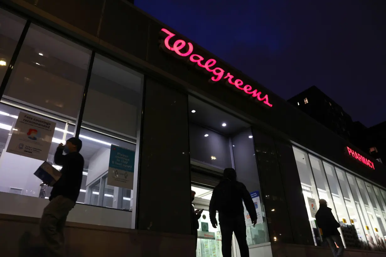 FILE PHOTO: People walk by a Walgreens, owned by the Walgreens Boots Alliance, Inc., in Manhattan, New York City