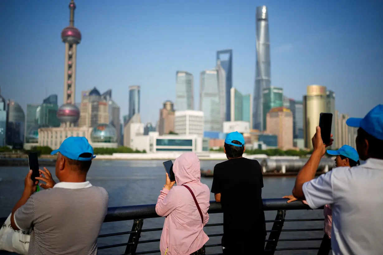 People visit the Bund on a hot day, in Shanghai