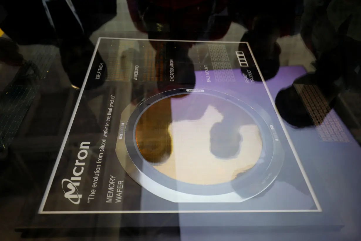 Visitors look at a memory wafer at Micron Technology kiosk before the start of 'SemiconIndia 2023' in Gandhinagar