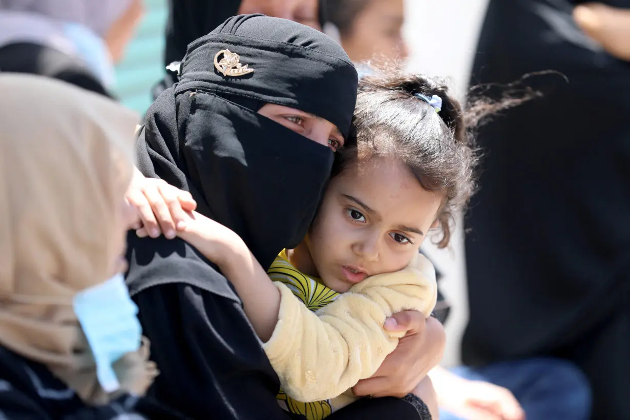 Mourners react as people rebury the bodies of Palestinians killed during Israel's military offensive and buried earlier at Nasser hospital, in Khan Younis