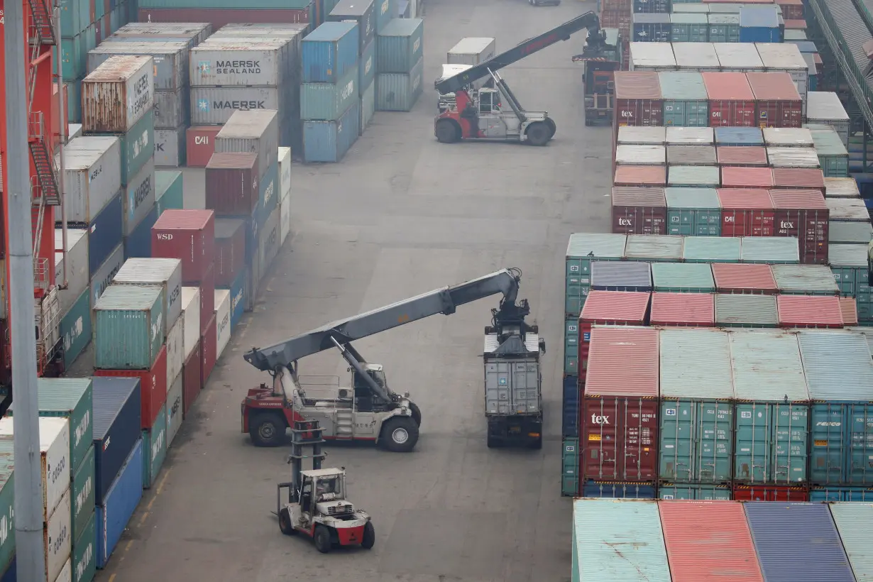 Trucks move shipping containers at a container terminal at Incheon port in Incheon