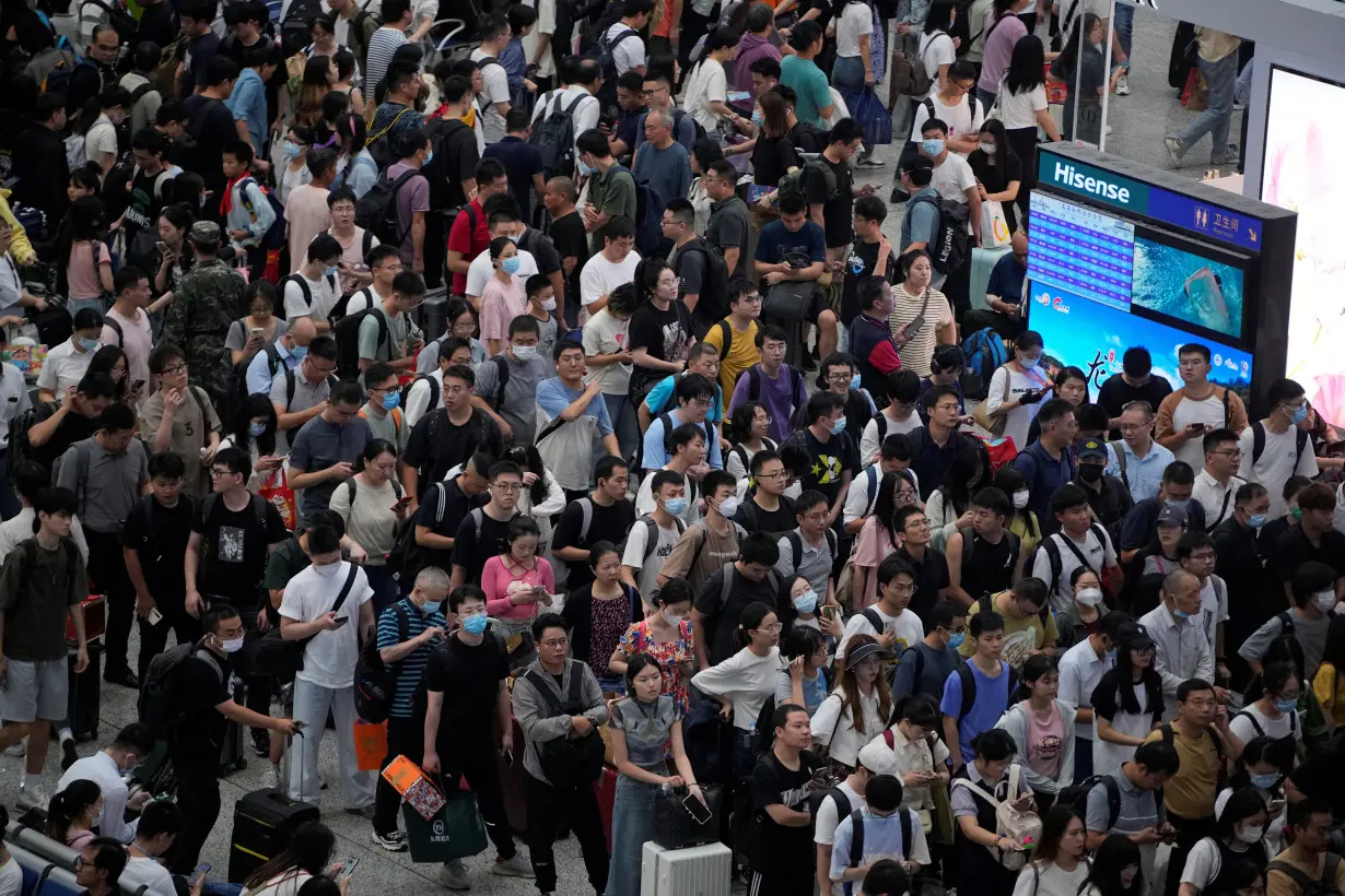 People wait to board trains at the Shanghai Hongqiao railway station ahead of the National Day holiday, in Shanghai