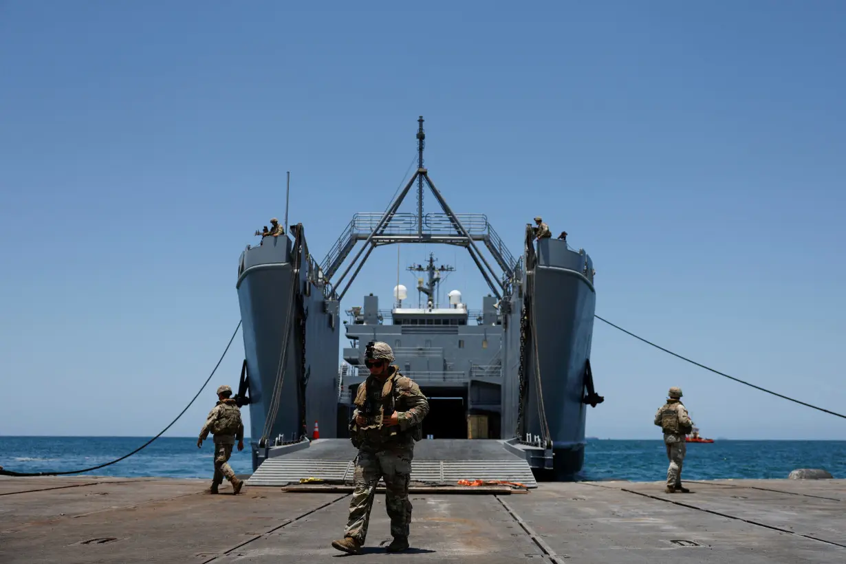 Trucks carry humanitarian aid across Trident Pier