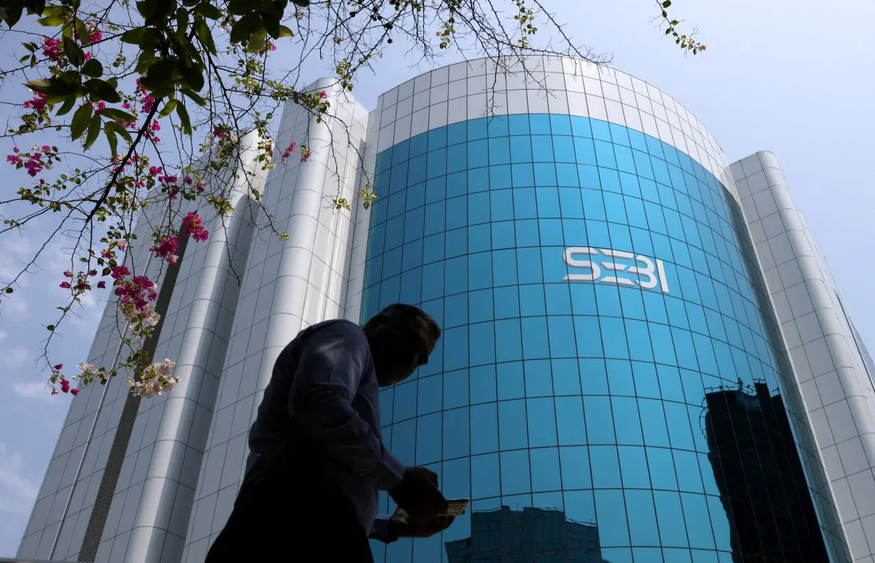 FILE PHOTO: A man walks past the Securities and Exchange Board of India (SEBI) headquarters in Mumbai