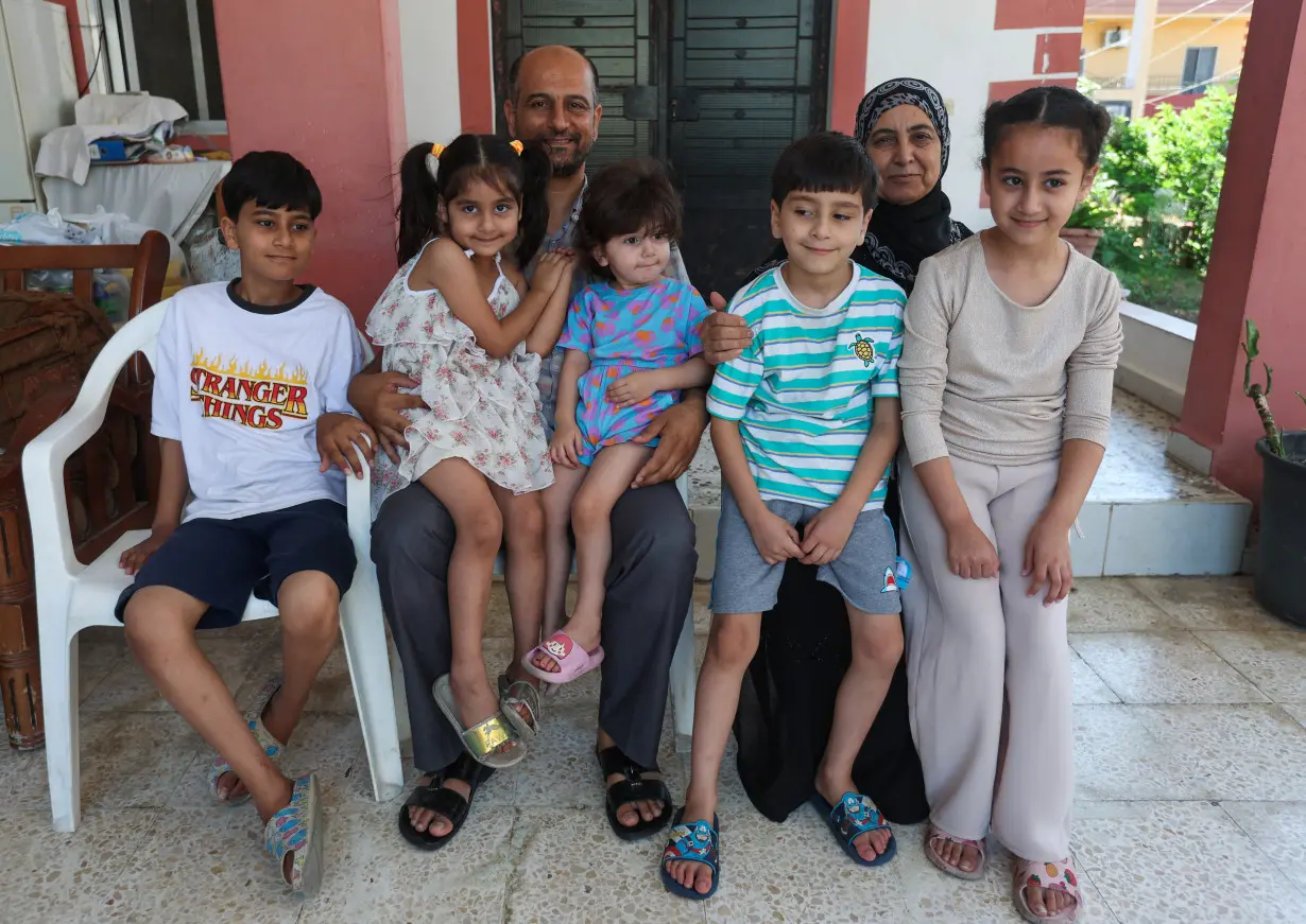 Samer Abu Della, displaced Lebanese from southern border village of Yarine, poses for a picture with his mother Adibeh, and children in Baisariyeh