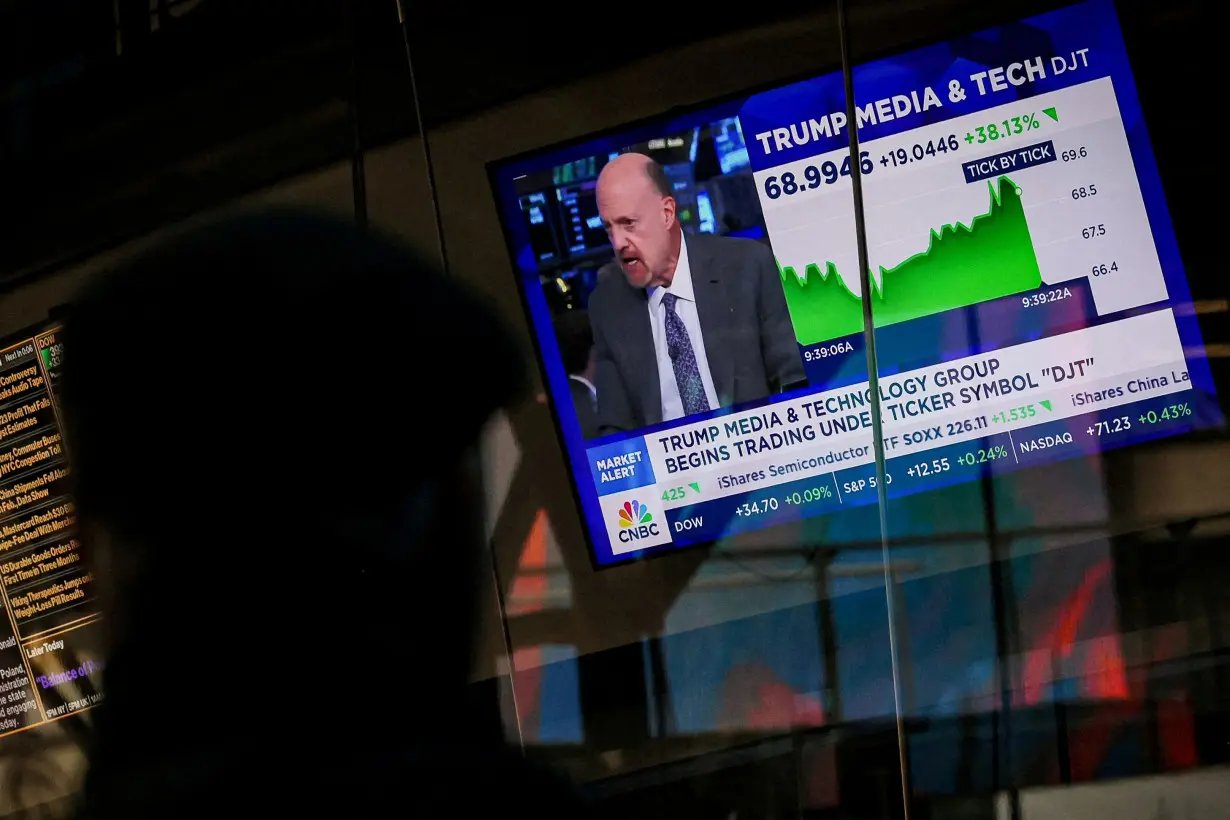 A man looks at a screen that displays trading information about shares of Truth Social and Trump Media & Technology Group in New York