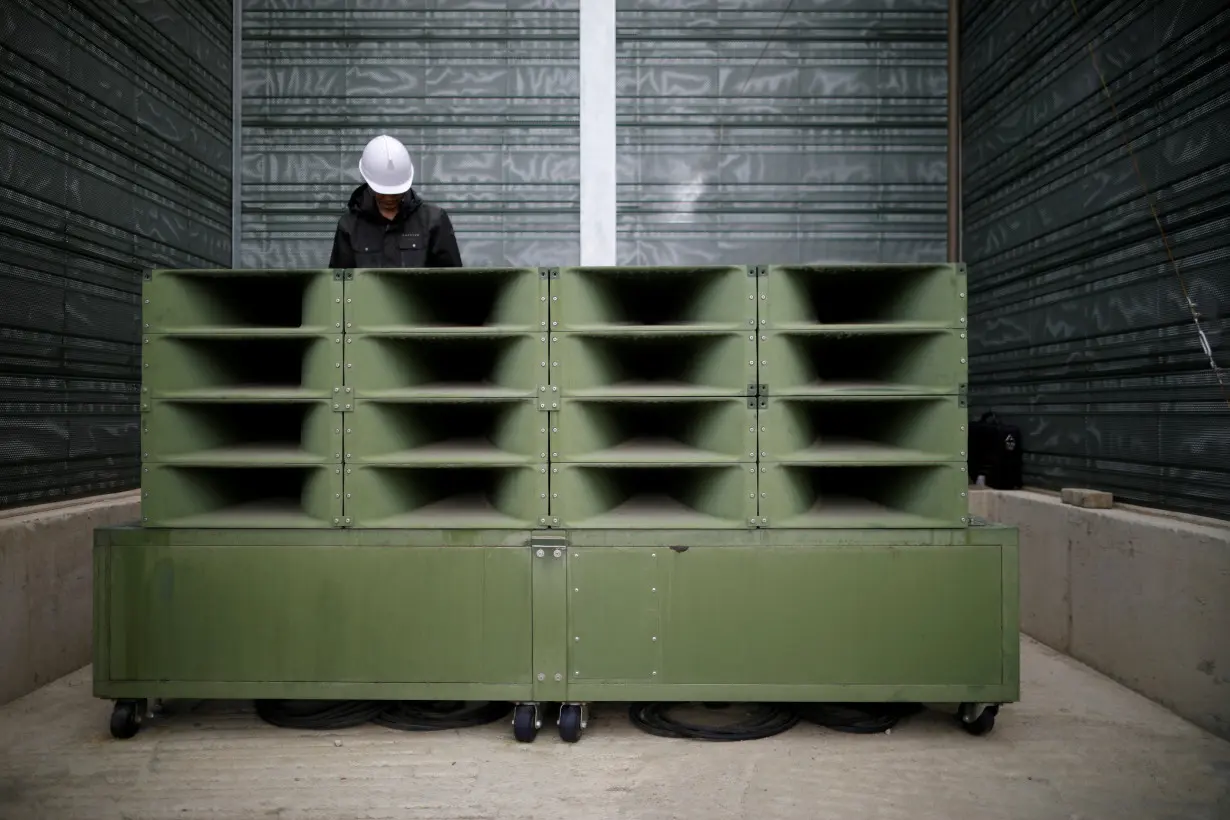 A worker dismantles loudspeakers that were set up for propaganda broadcasts near the demilitarized zone separating the two Koreas in Paju