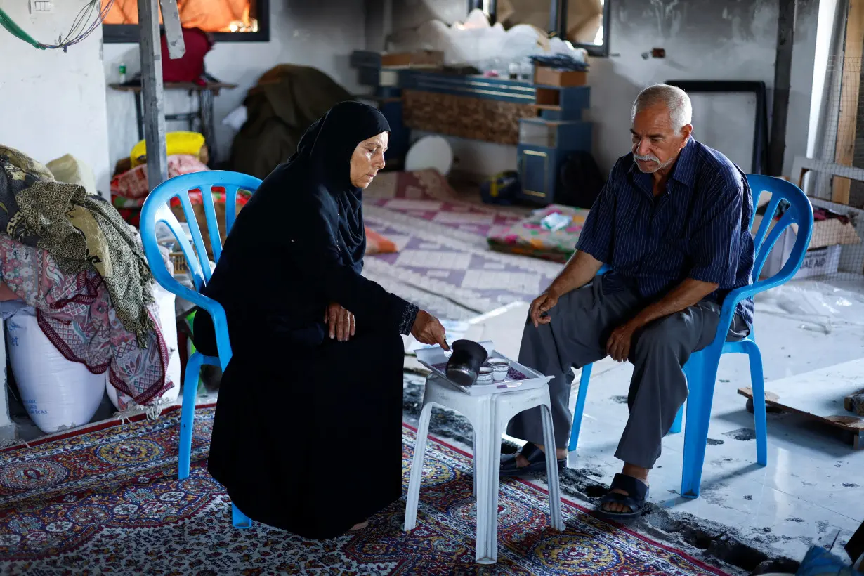 Palestinian couple Mahmoud and Fatima Jarghoun sit inside their damaged home, in Khan Younis