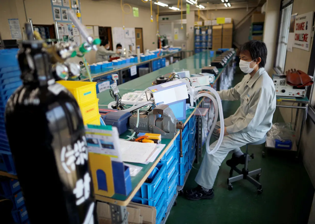 FILE PHOTO: Employees of Sanko Manufacturing Co. are seen at the assemble line of the company's ventilators at the factory in Saitama