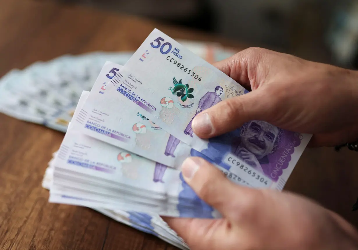 An employee counts Colombian pesos in an exchange house, in Bogota