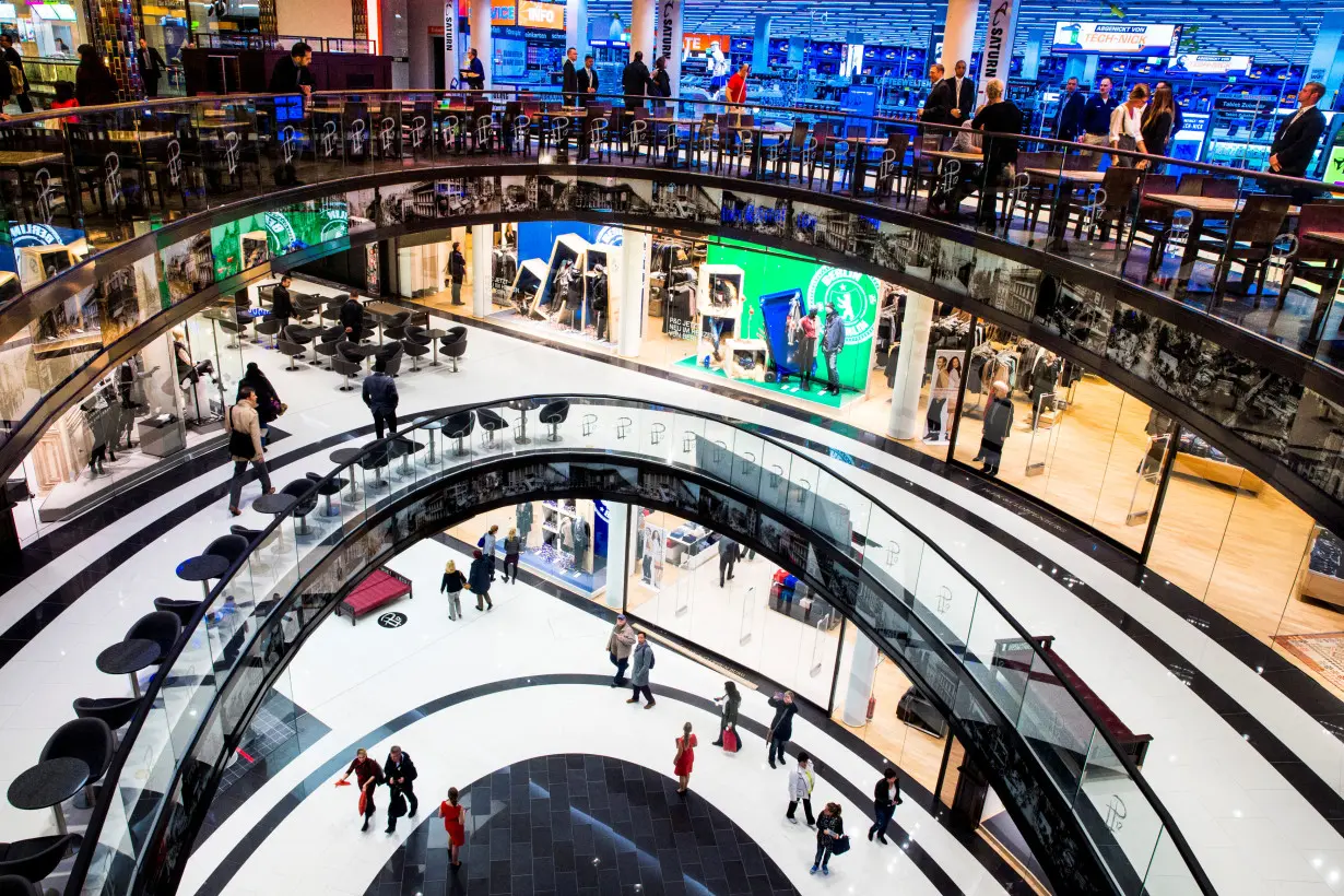 People walk through Mall of Berlin shopping centre during its opening night in Berlin