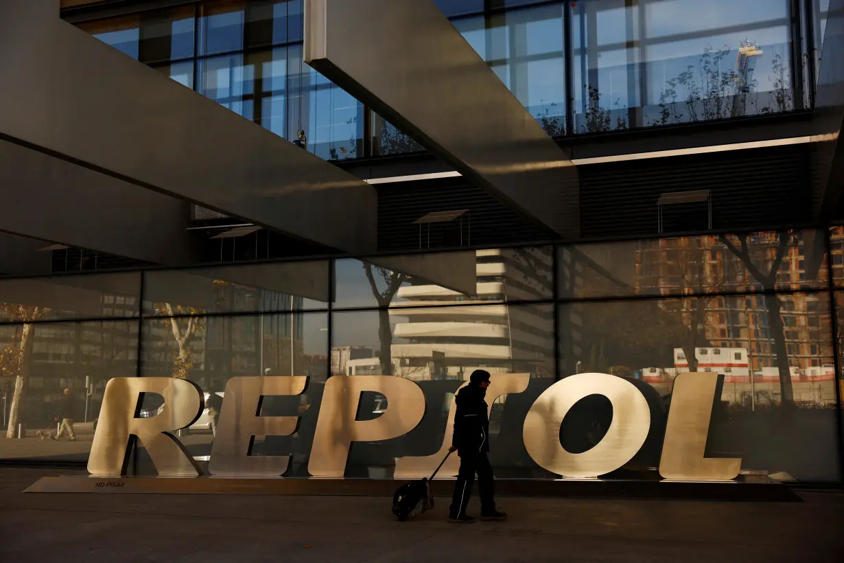 FILE PHOTO: A man walks past the logo of Spanish oil major Repsol outside its headquarters in Madrid
