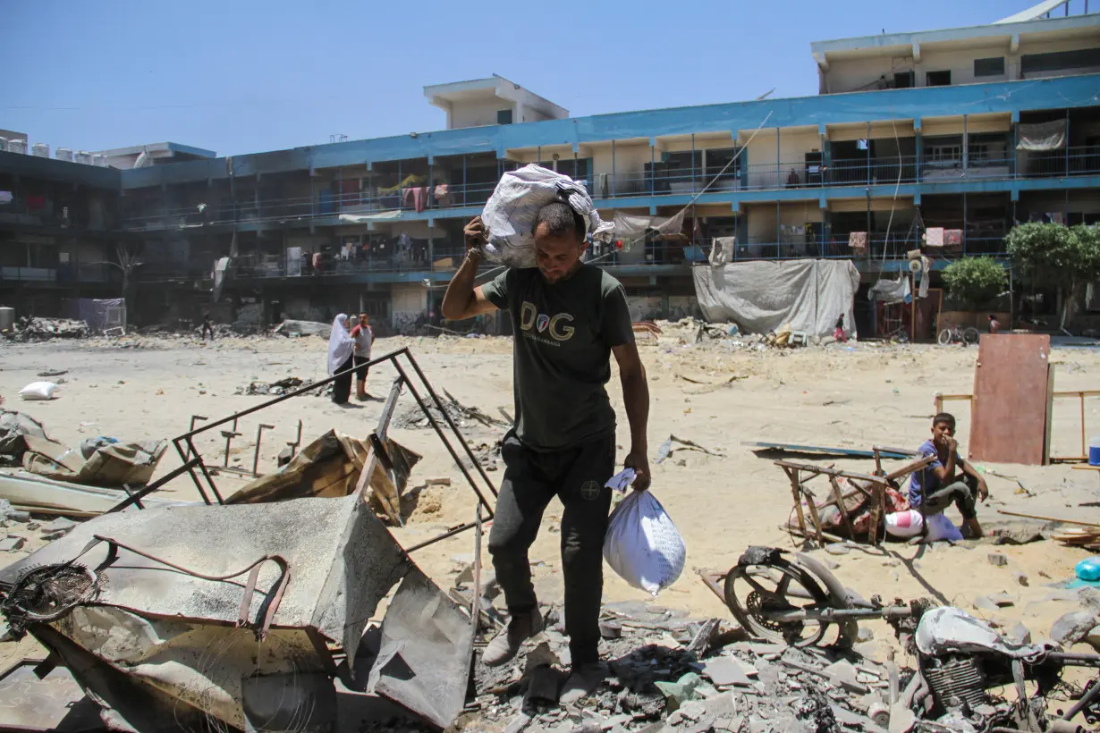 Displaced Palestinian family returns to a damaged school following Israeli raid