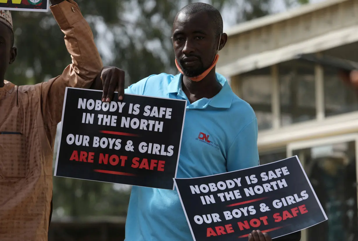 FILE PHOTO: A demonstrator holds signs during a protest to urge authorities to rescue hundreds of abducted schoolboys, in northwestern state of Katsina