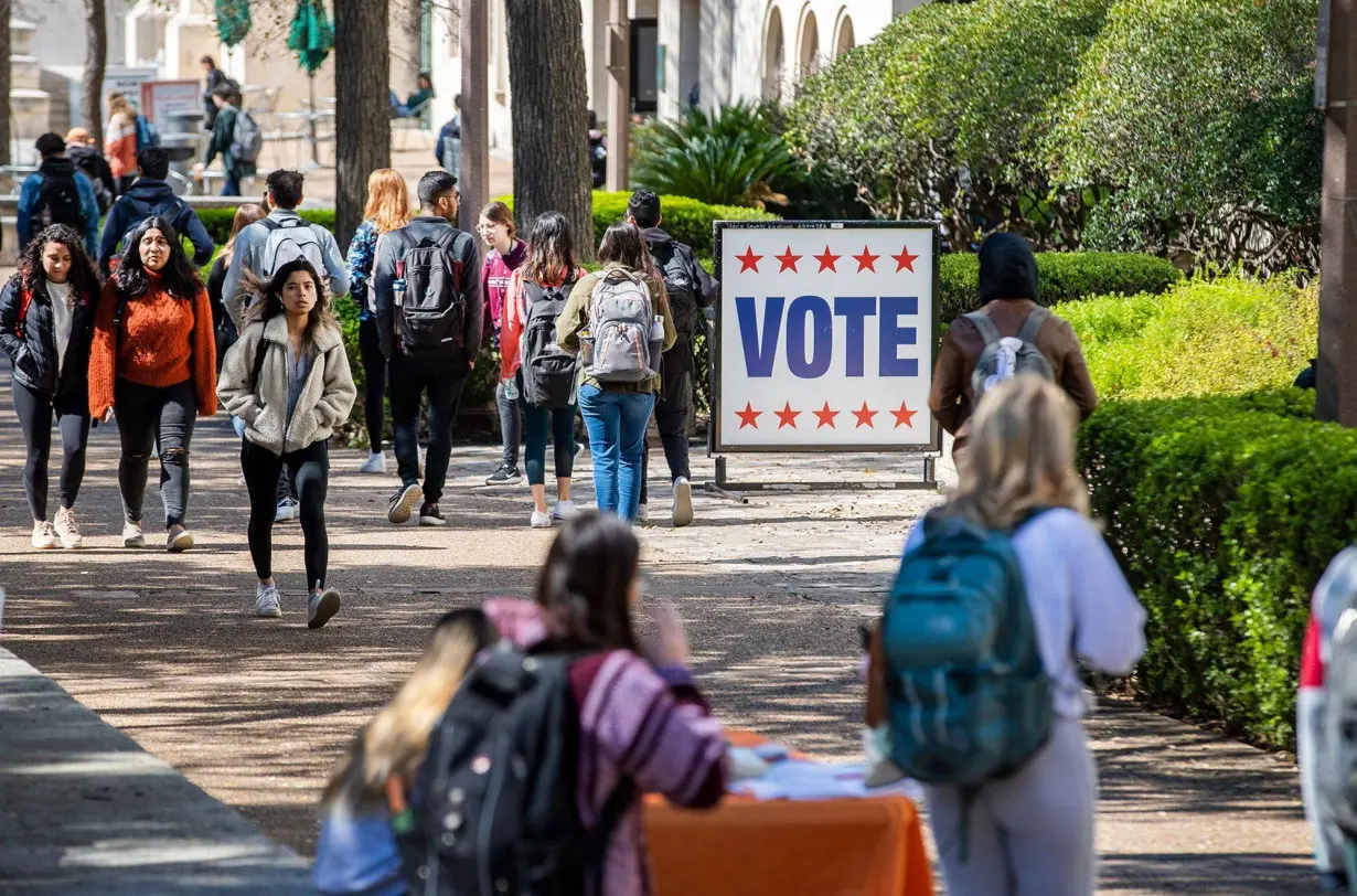 Students walk by an early voting site on the campus of the University of Texas at Austin in February 2020.