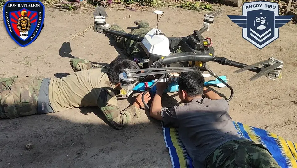 People prepare a drop bomb attached to a drone at a workshop at undisclosed location in Myanmar