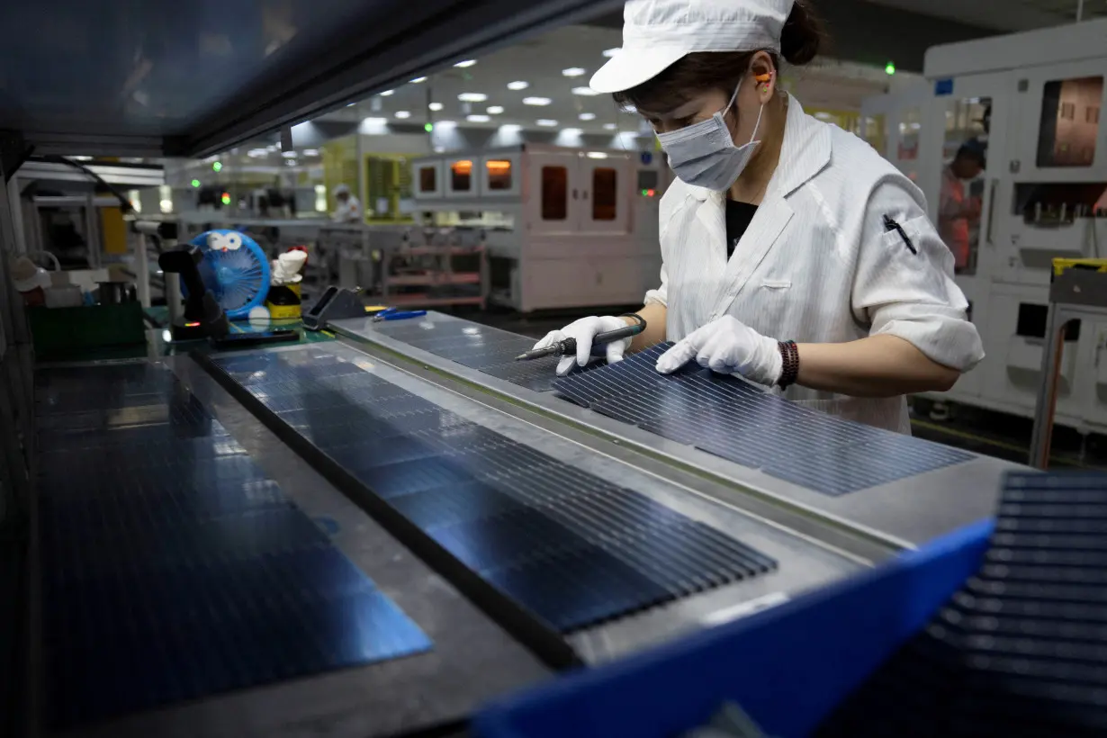 FILE PHOTO: Employee works on the production line for solar panels in Hefei