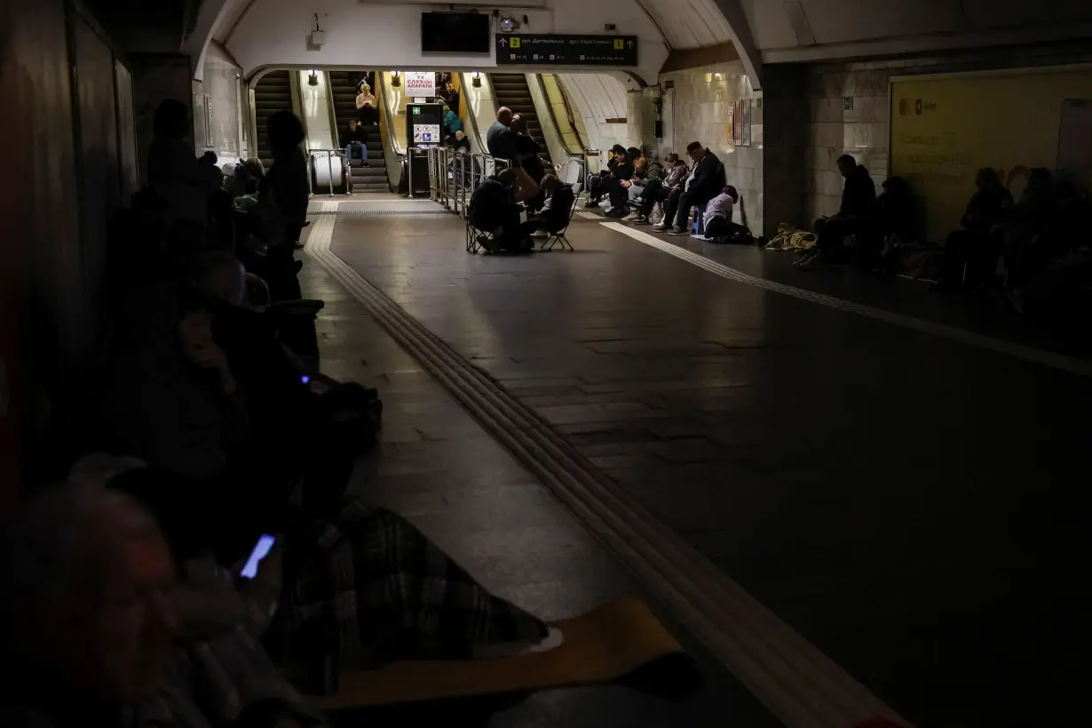 People take shelter inside a metro station during a Russian military attack, in Kyiv