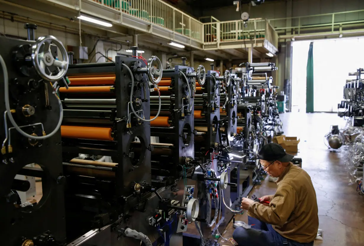 FILE PHOTO: A worker checks machinery at a factory in Higashiosaka