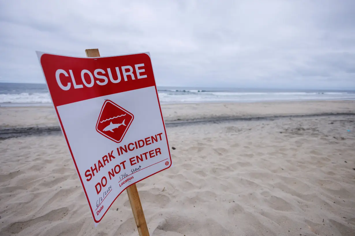 A shark warning sign keeps swimmers and surfers out of the water following shark attack