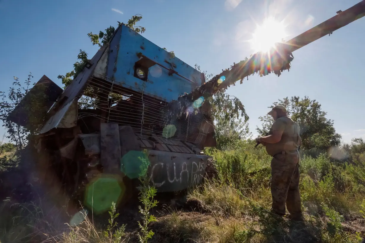 A Ukrainian serviceman appears next to a recently captured Russian T-62 Soviet main battle tank, in Donetsk region