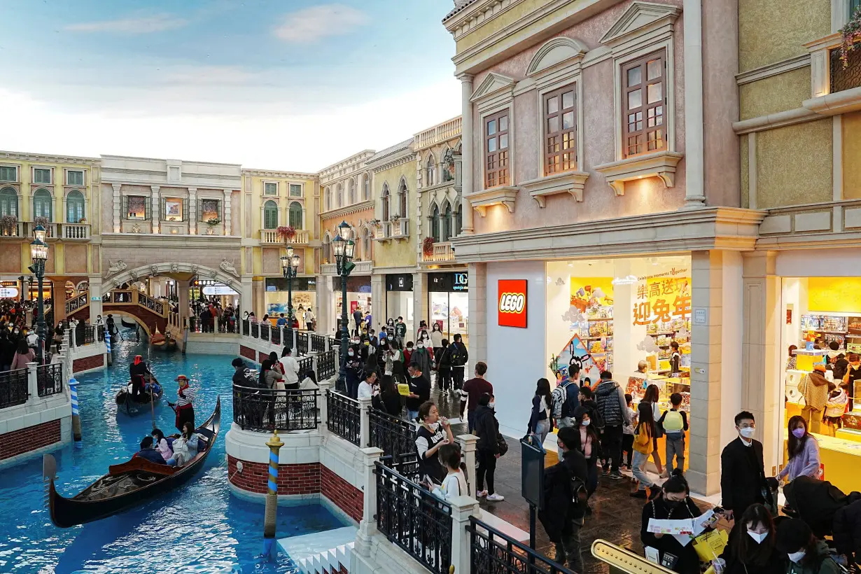 FILE PHOTO: Visitors shop at the Grand Canal shop inside the Venetian Macao hotel which is operated by Sands China during Lunar New Year in Macau