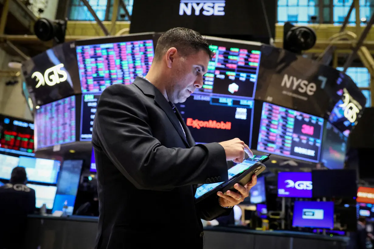 FILE PHOTO: Traders work on the floor of the NYSE in New York