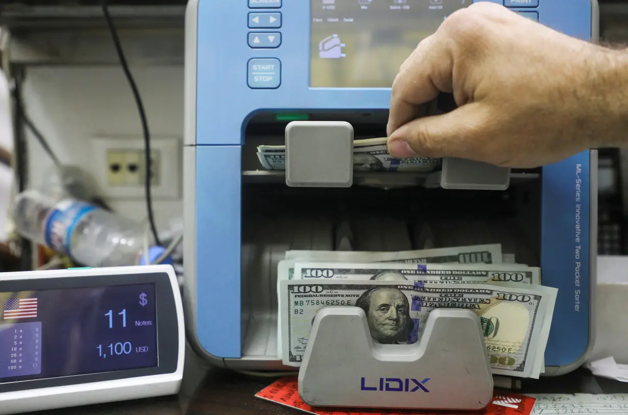 A man counts U.S. dollar banknotes at an exchange shop in Beirut