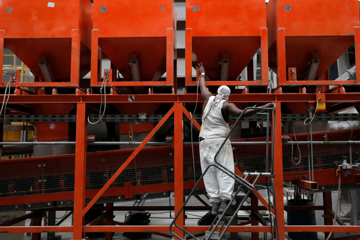 A worker checks equipment in the factory at IceStone, a manufacturer of recycled glass countertops and surfaces, in New York City