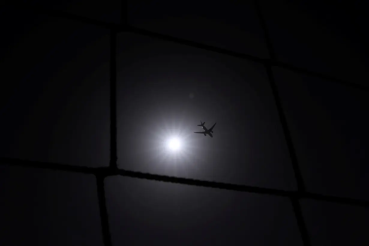 A Qatar Airways plane flies over Dubai