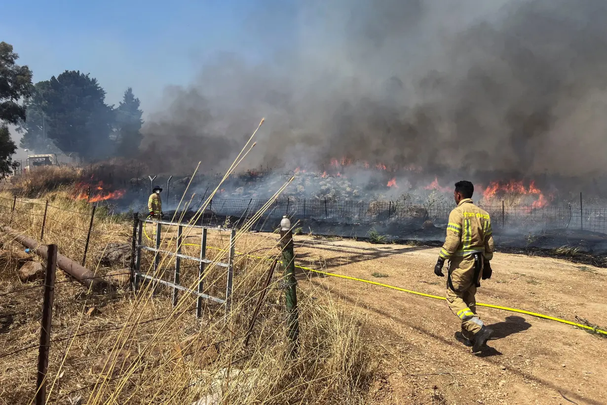 Israeli firefighters work following rocket attacks from Lebanon, amid ongoing cross-border hostilities between Hezbollah and Israeli forces, near the border on its Israeli side