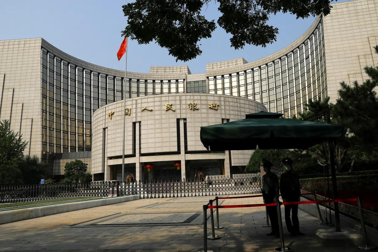 FILE PHOTO: FILE PHOTO: Paramilitary police officers stand guard in front of the headquarters of PBOC in Beijing