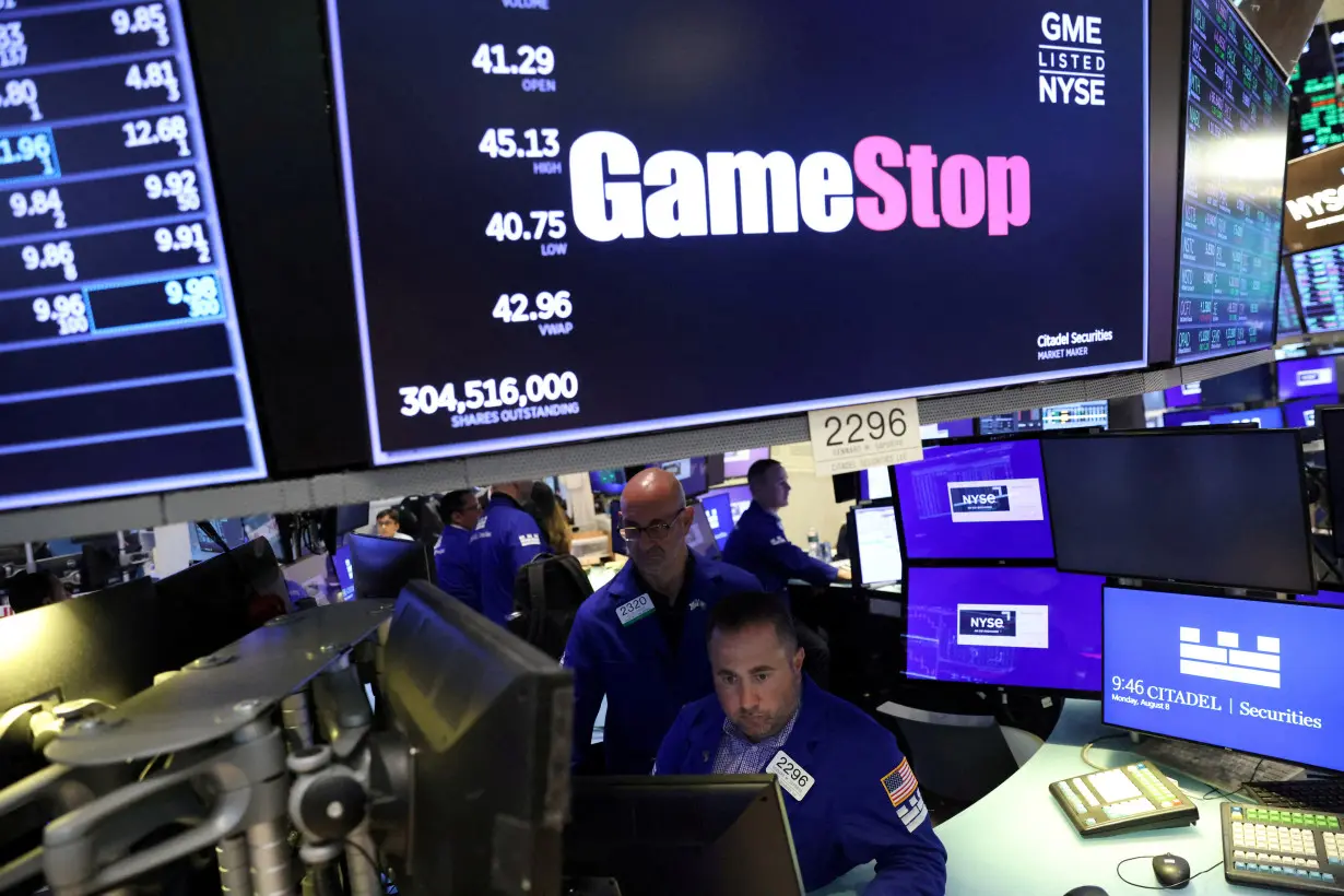 FILE PHOTO: Traders work under signage for GameStop Corp. (NYSE: GME) on the trading floor at the New York Stock Exchange (NYSE) in Manhattan, New York City