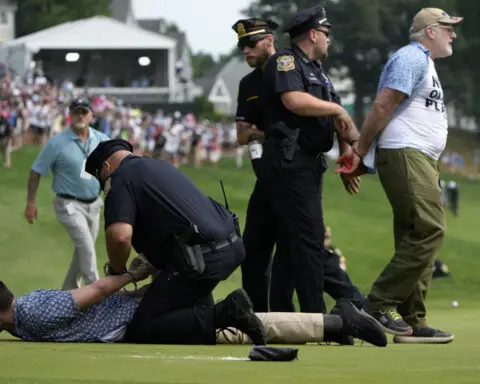Six climate protesters run onto 18th green and spray powder, delaying finish of PGA Tour event