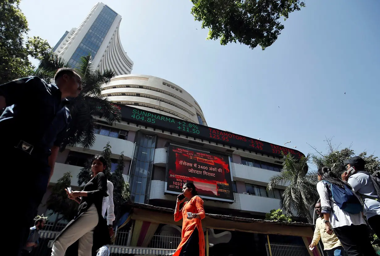 People walk past the Bombay Stock Exchange building in Mumbai