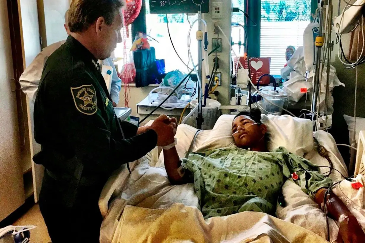 Sheriff Scott Israel holds the hand of Anthony Borges in 2018.