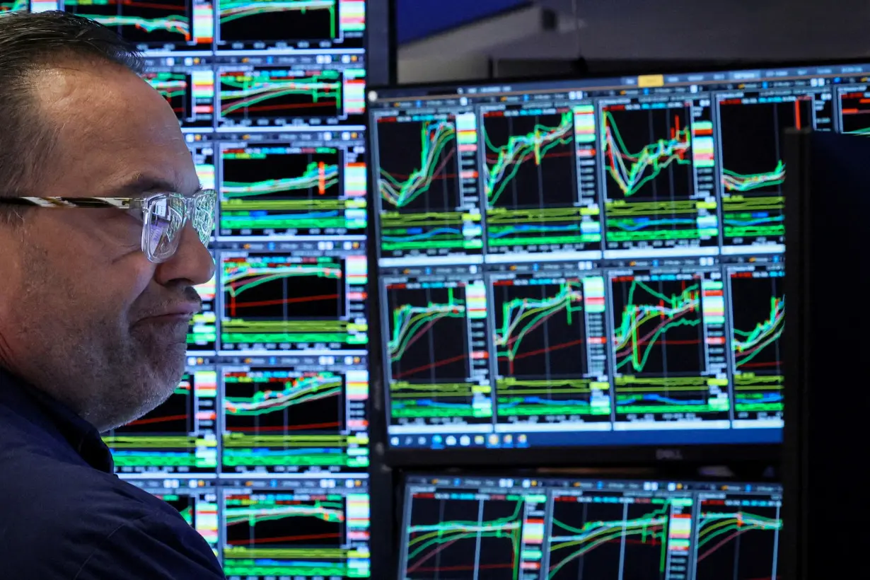 FILE PHOTO: Traders work on the floor of the NYSE in New York