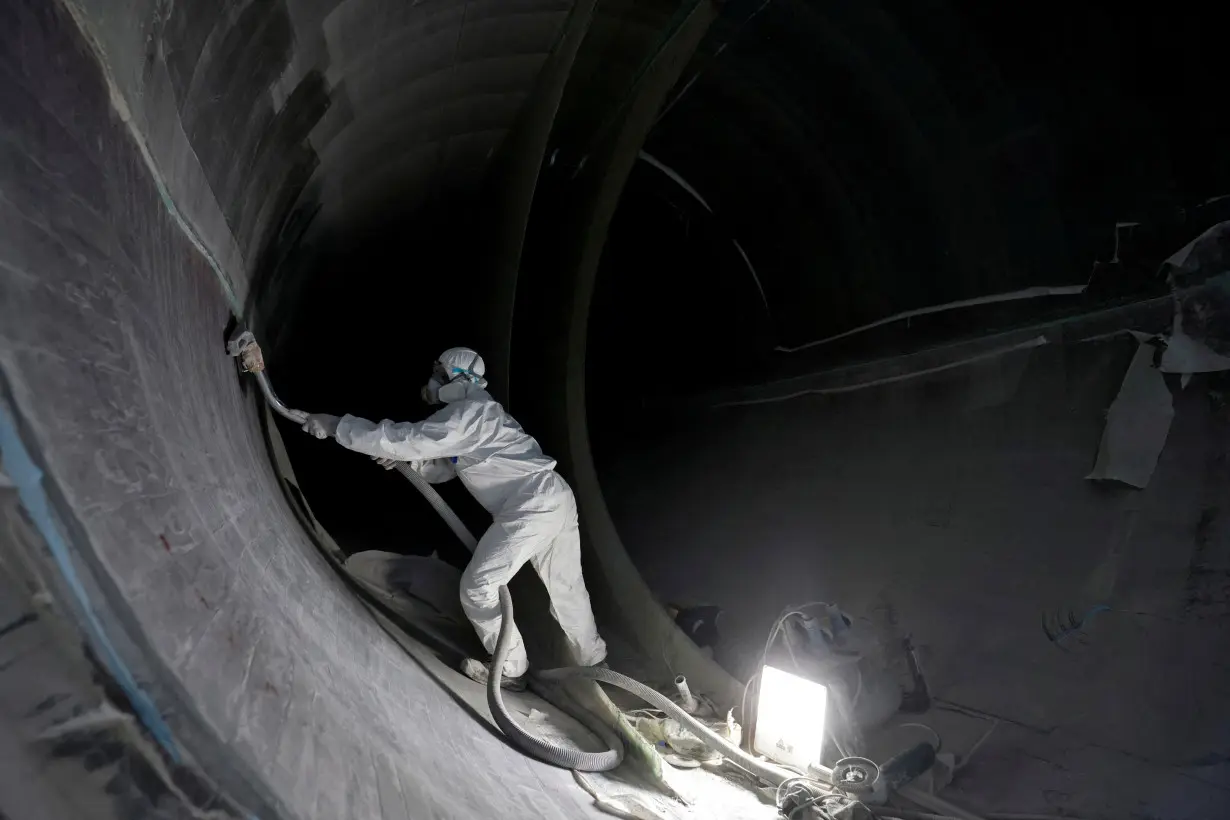 FILE PHOTO: A worker prepares a blade of a power-generating windmill turbine at the plant of Adani Green Energy Ltd (AGEL) in Mundra