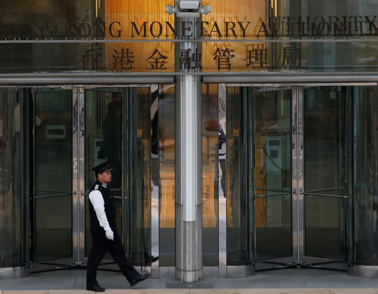 An attendant walks outside the entrance to Hong Kong Monetary Authority in Hong Kong