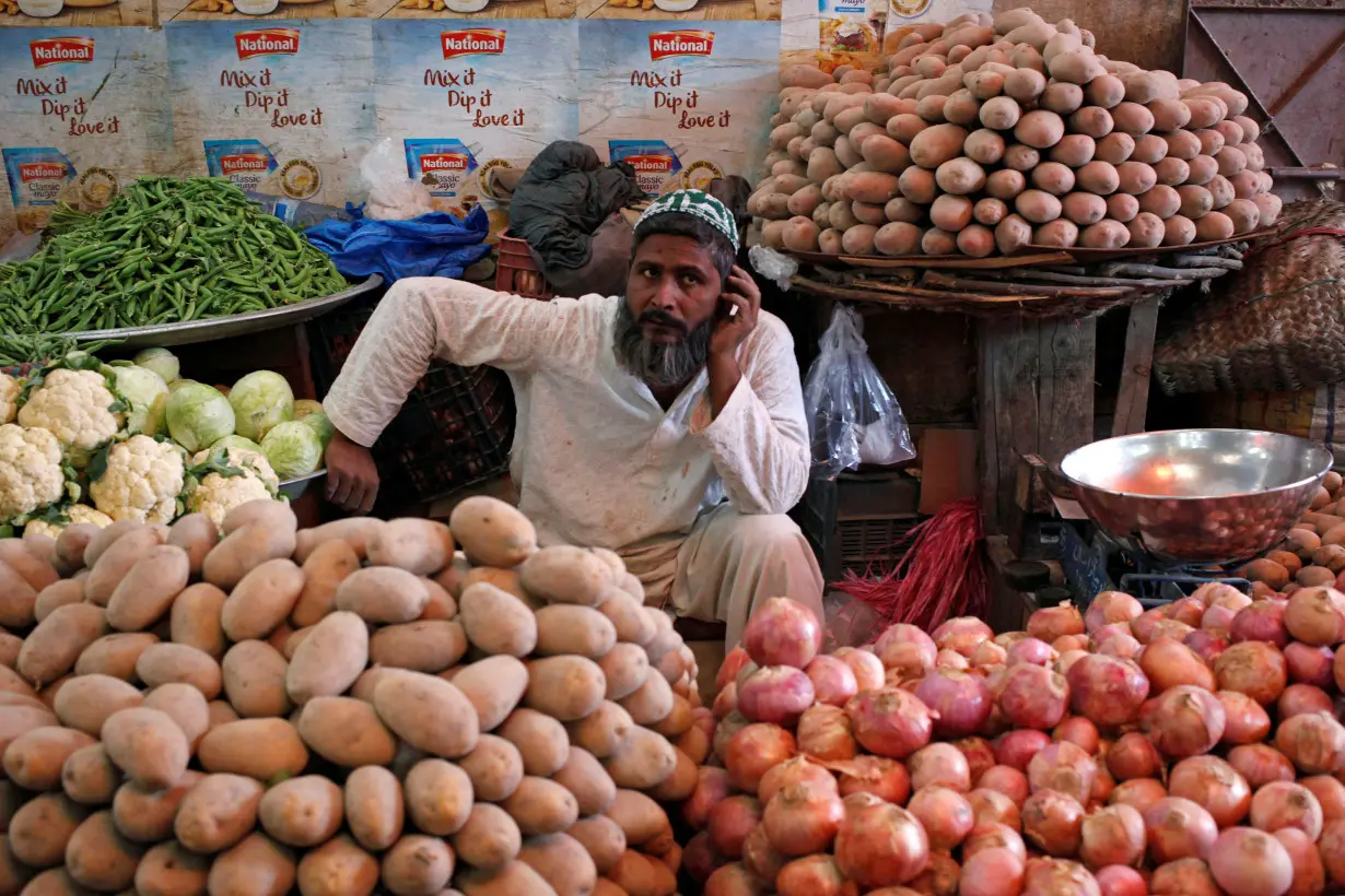 A man selling vegetables waits for customers at his makeshift stall at the Empress Market in Karachi