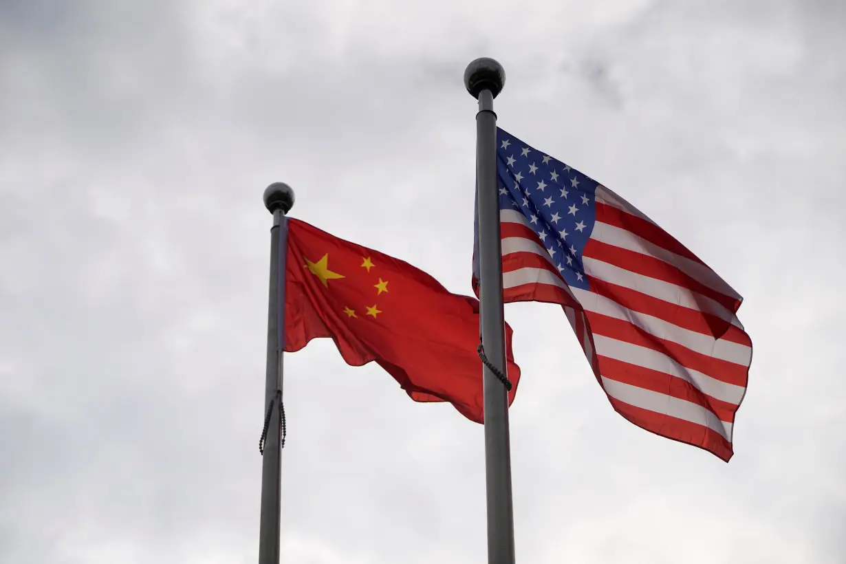 Chinese and U.S. flags flutter outside a company building in Shanghai