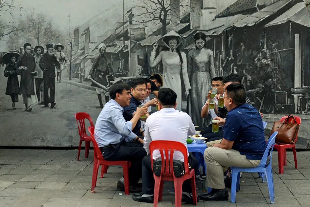 FILE PHOTO: Men drink beer on the street in Hanoi, Vietnam