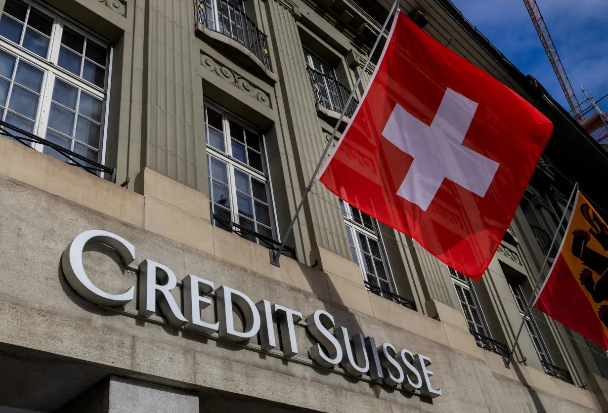 FILE PHOTO: FILE PHOTO: A Swiss flag is pictured above a logo of Swiss bank Credit Suisse in Bern